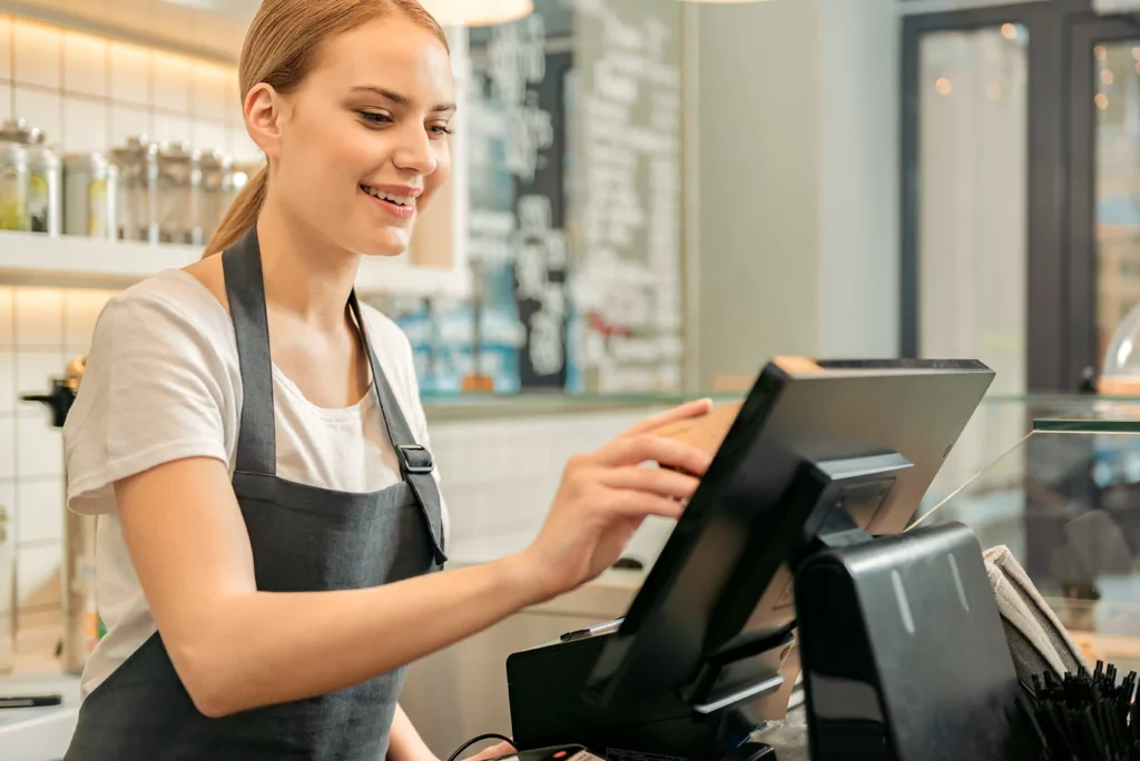 Smiling employee puts an order through the till