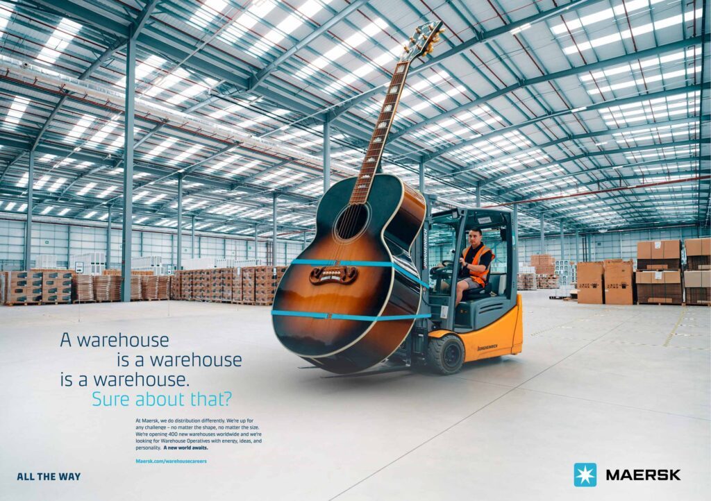 Maersk warehouse employer branding: man in warehouse using forklift to hold huge guitar.