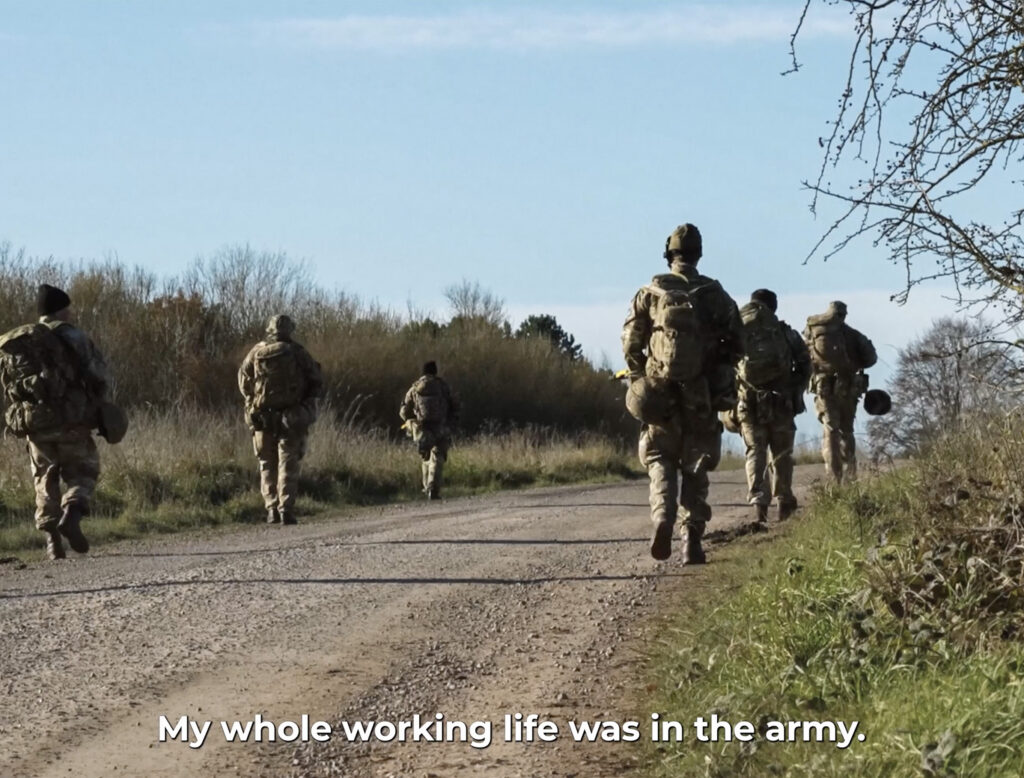 People walking down a dirt path in their army gear
